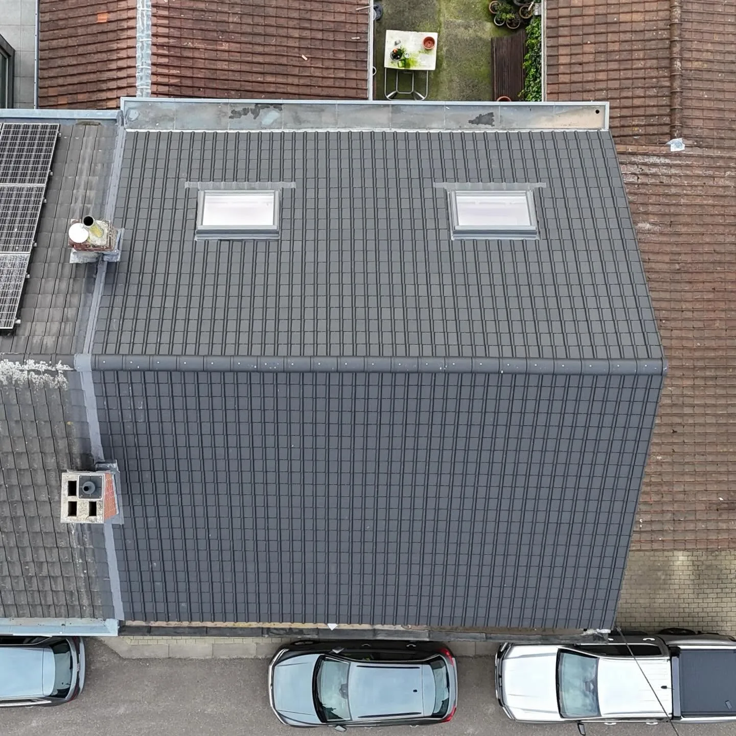 Vue de drone verticale d'un toit de tuiles anthracite neuves avec deux fenêtres de toit