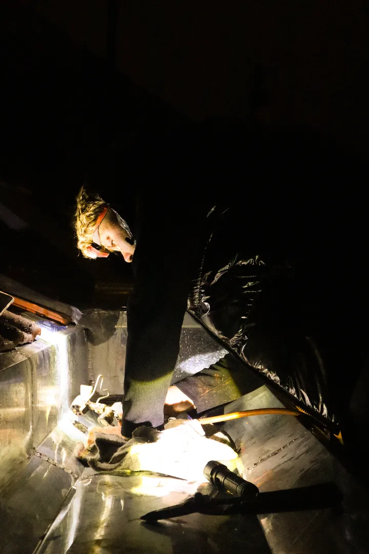 Un couvreur de l'équipe Le Fils travaille à la lampe frontale sous une toiture